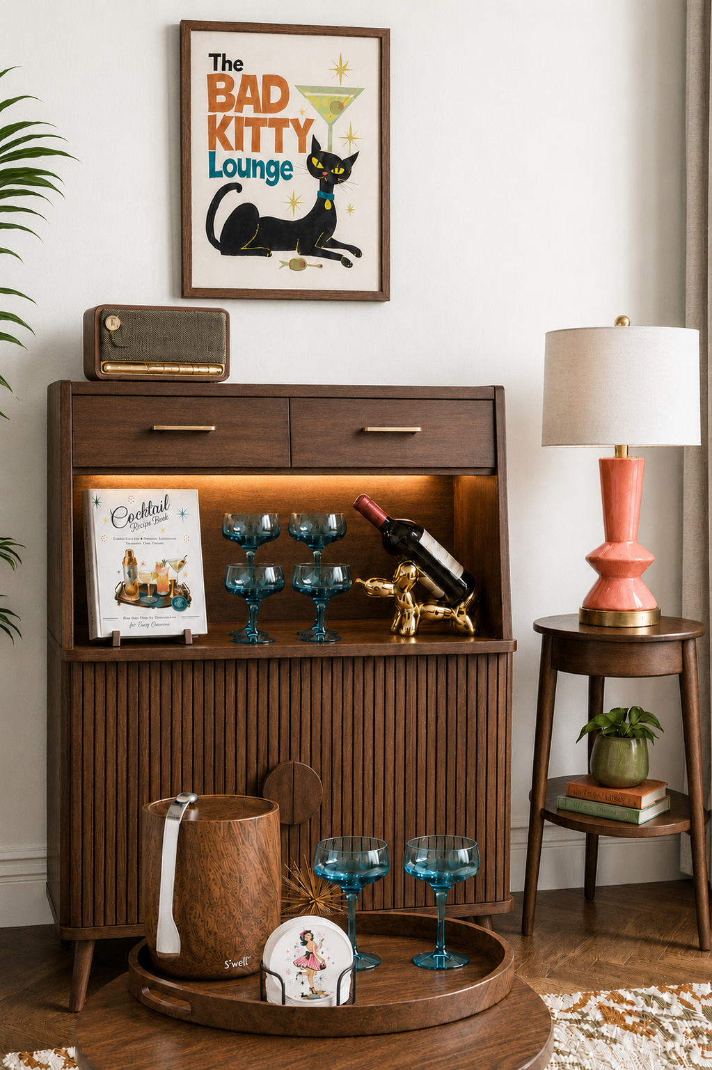 Fresh mid century home bar with Whippie’s cocktail book, ceramic coasters, blue coupe glasses, ice bucket, and retro decor