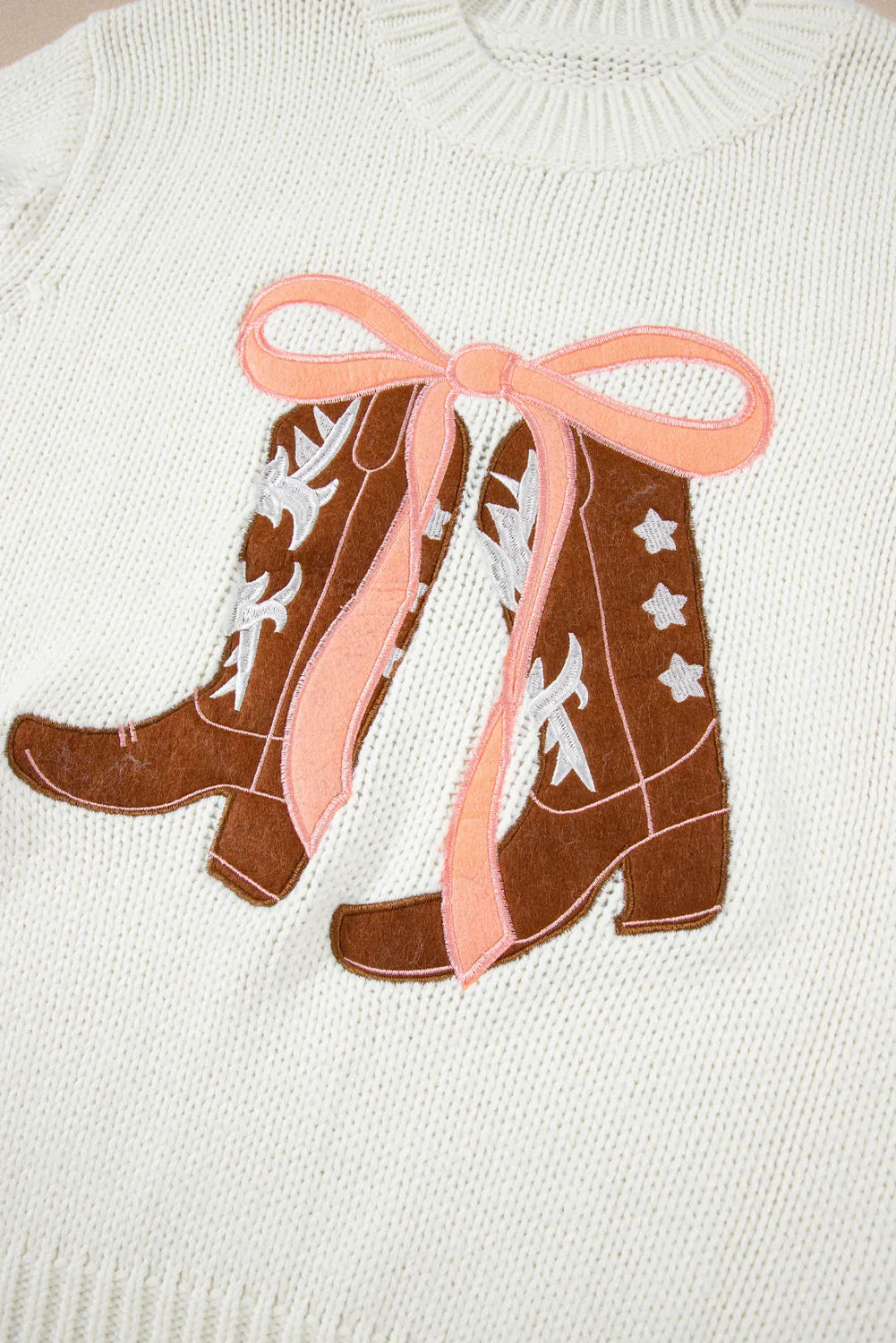 Cream knit sweater with brown embroidered cowboy boots and pink bow applique