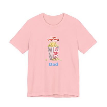 Light pink T-shirt with a graphic of a popcorn bucket and text reading 'I Love Popcorn Dad'