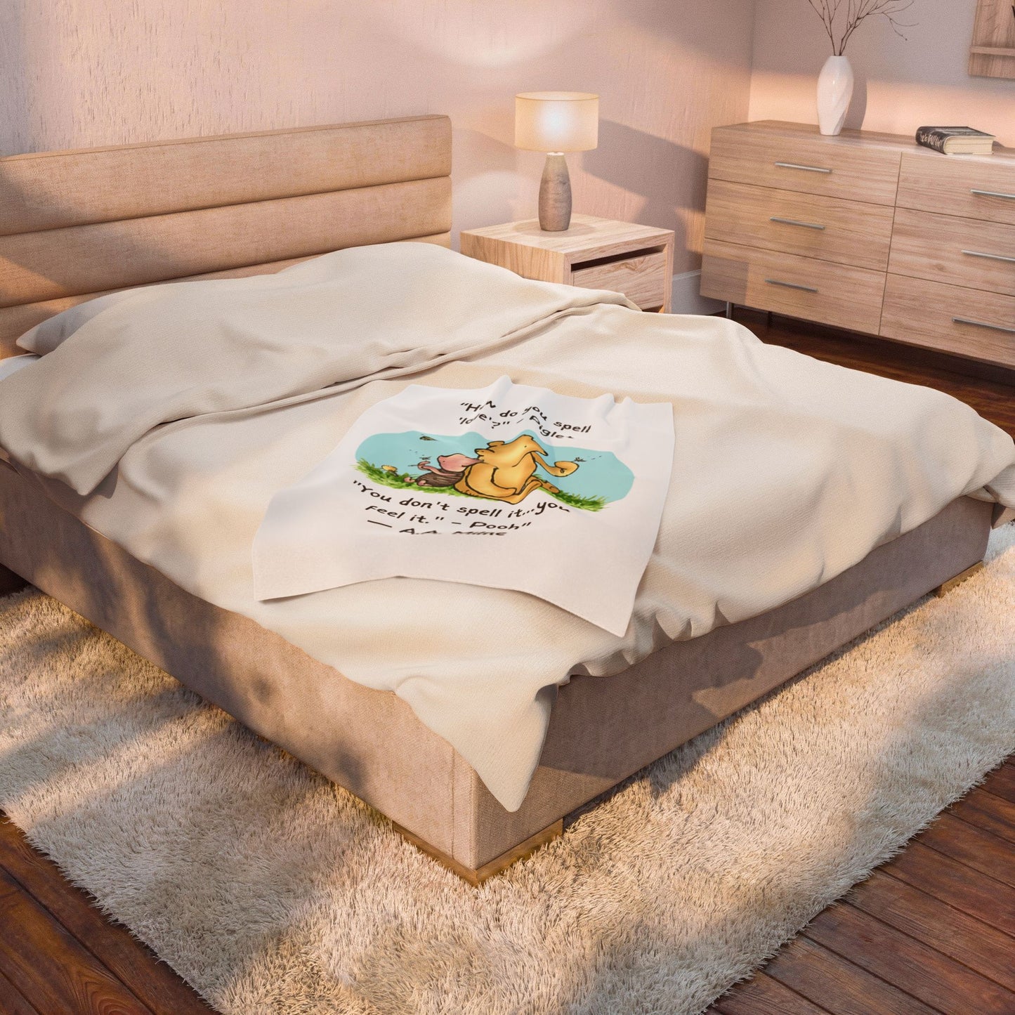 baby crib blankt 40" x 60" with a logo on a  queen bed in a bedroom setting. Blanket takes up a quarter of the bed.