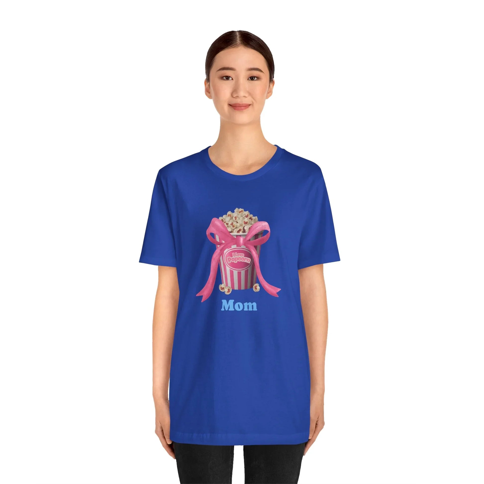 Woman wearing blue T-shirt with popcorn bucket and pink bow graphic, Mom text