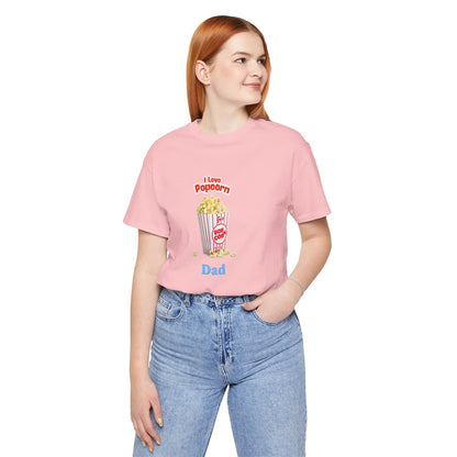 Woman wearing pink t-shirt with popcorn illustration and text 'I Love Popcorn Dad', paired with blue jeans
