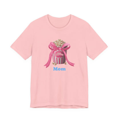 Pink t-shirt with popcorn bucket graphic tied with pink ribbon and blue Mom text