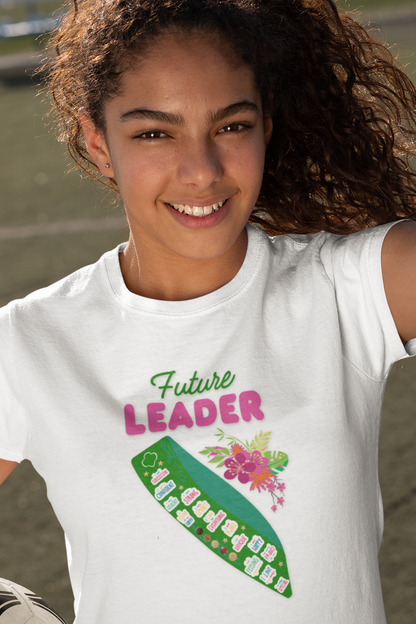 Person wearing a white t-shirt with 'Future Leader' text and a green ribbon graphic, holding a soccer ball.