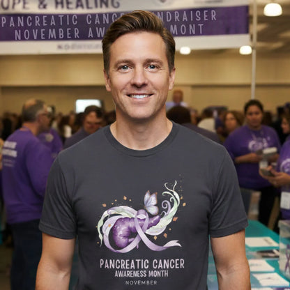 Man wearing a t-shirt with pancreatic cancer awareness design at an event.
