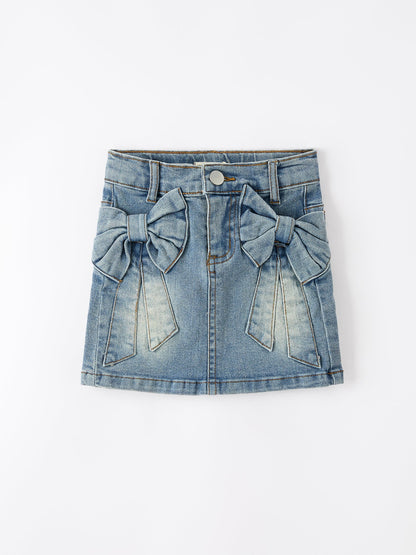 Blue denim skirt with bow details on a white background
