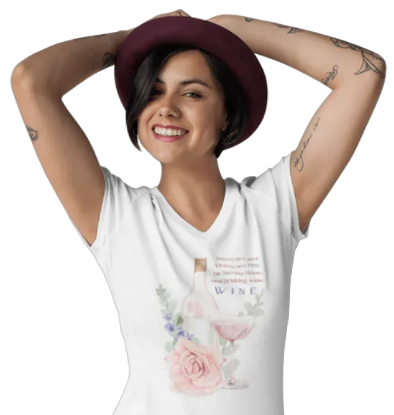 Woman wearing a white t-shirt with floral design and text "Roses Are Red, Violets are FINE, I'm Staying Home and Drinking WINE", posing with hands behind her head on a white background.