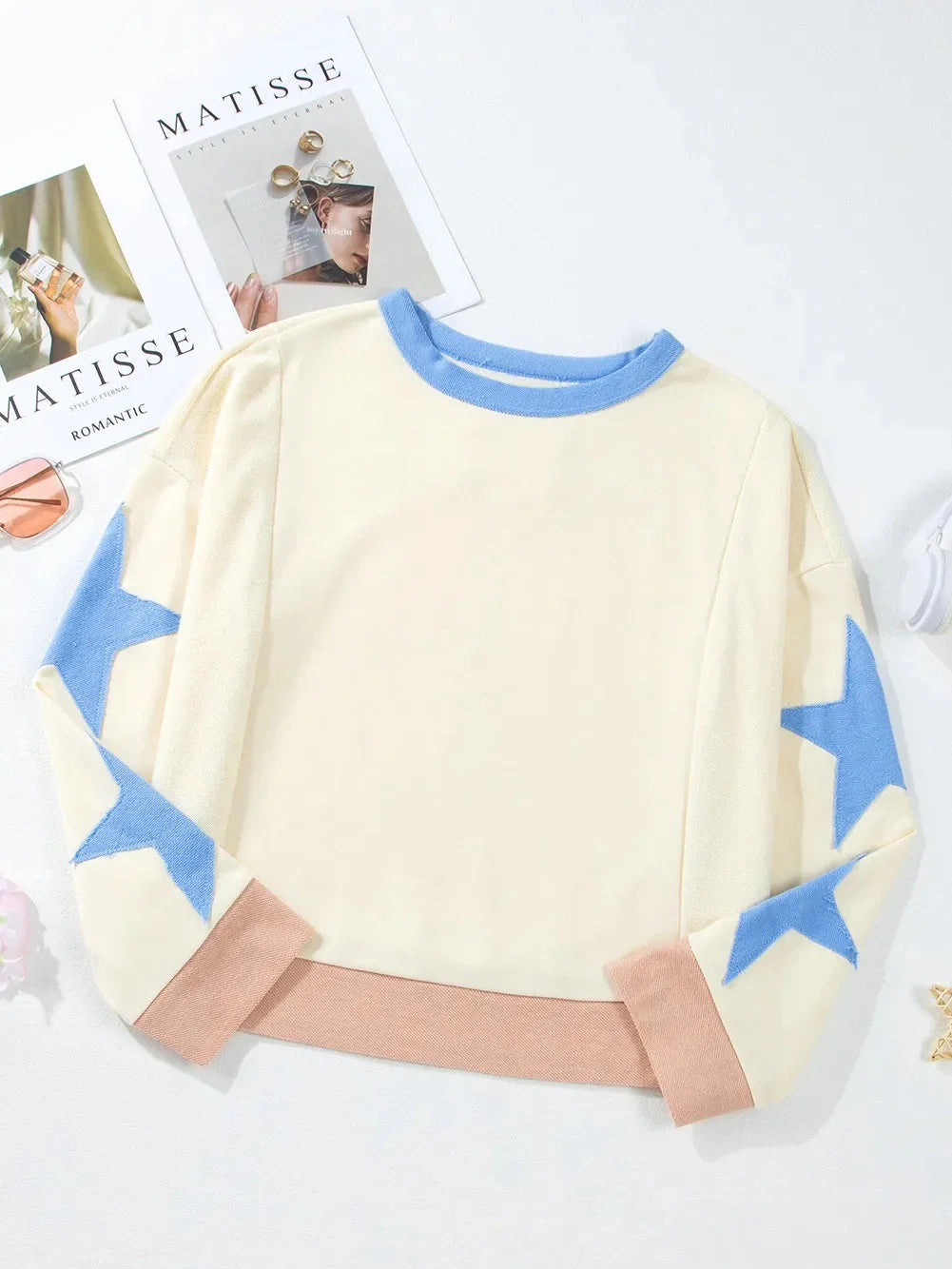 Children's sweater with blue star patterns on a white background