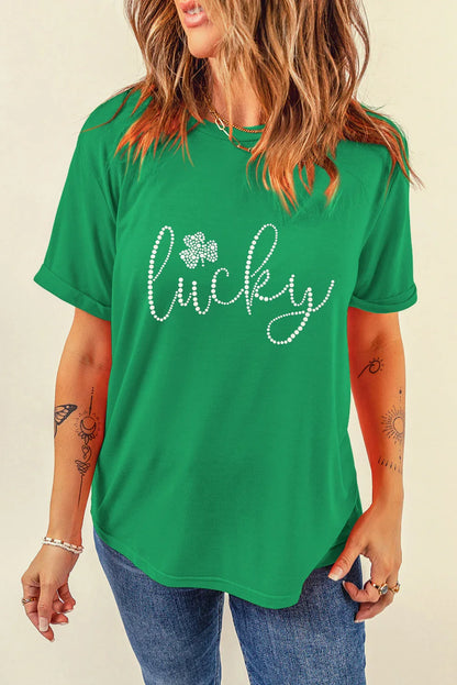 Woman wearing green t-shirt with rhinestone design spelling lucky and shamrock detail