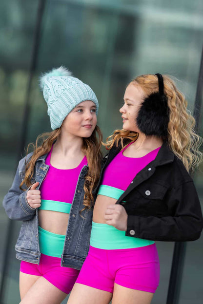two girls wearing horizon girls dancewear hot pink top with teal cross straps and bottoms in hot pink and teal accents.