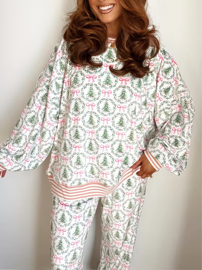 Woman wearing a festive pajama set with Christmas tree and bow pattern.