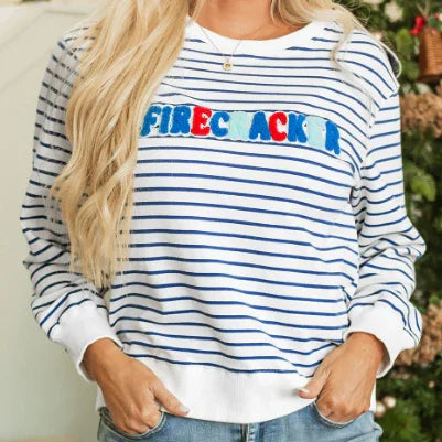 Woman wearing white and blue striped sweatshirt with colorful text 'FIRECRACKER' embroidered on front