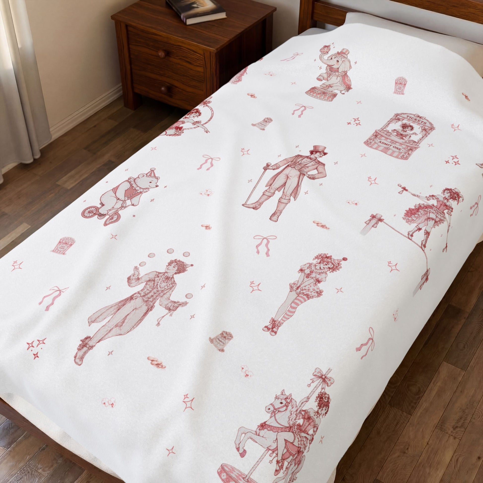 Bed with vintage-style throw blanket with red and pink coquette circus print in a bedroom setting.