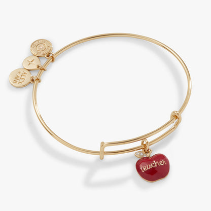 Gold bracelet with a red 'teacher' apple charm on a white background