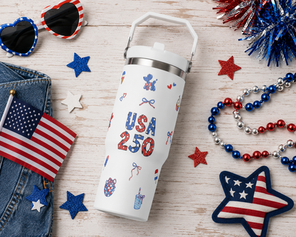 White tumbler with 'USA 250' design surrounded by 4th of July-themed accessories on a wooden surface.