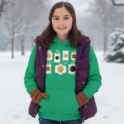 Girl wearing a green sweater with cookie design in a snowy landscape