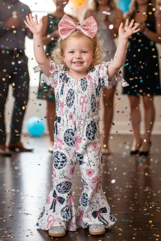 Child in a patterned outfit with confetti and balloons in a celebratory setting
