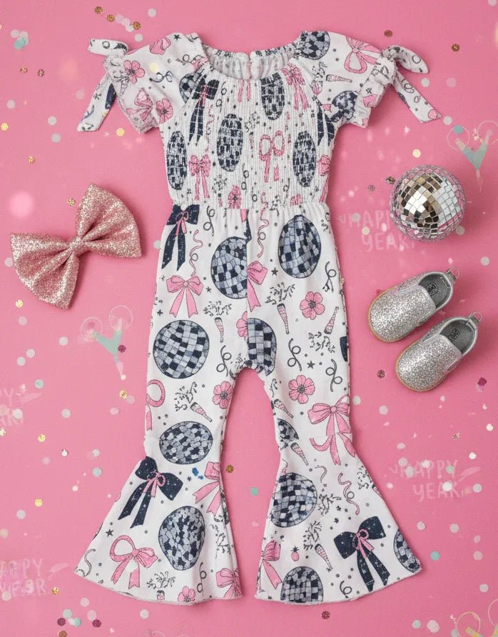 Children's romper with polka dot and bow pattern on a pink background with confetti and shoes.