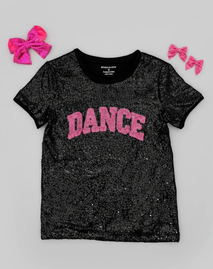 Black glittery t-shirt with 'DANCE' in pink on a gray background