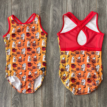 The Great Pumpkin Snoopy Halloween leotard front and red crossover mesh-back views on a wood background
