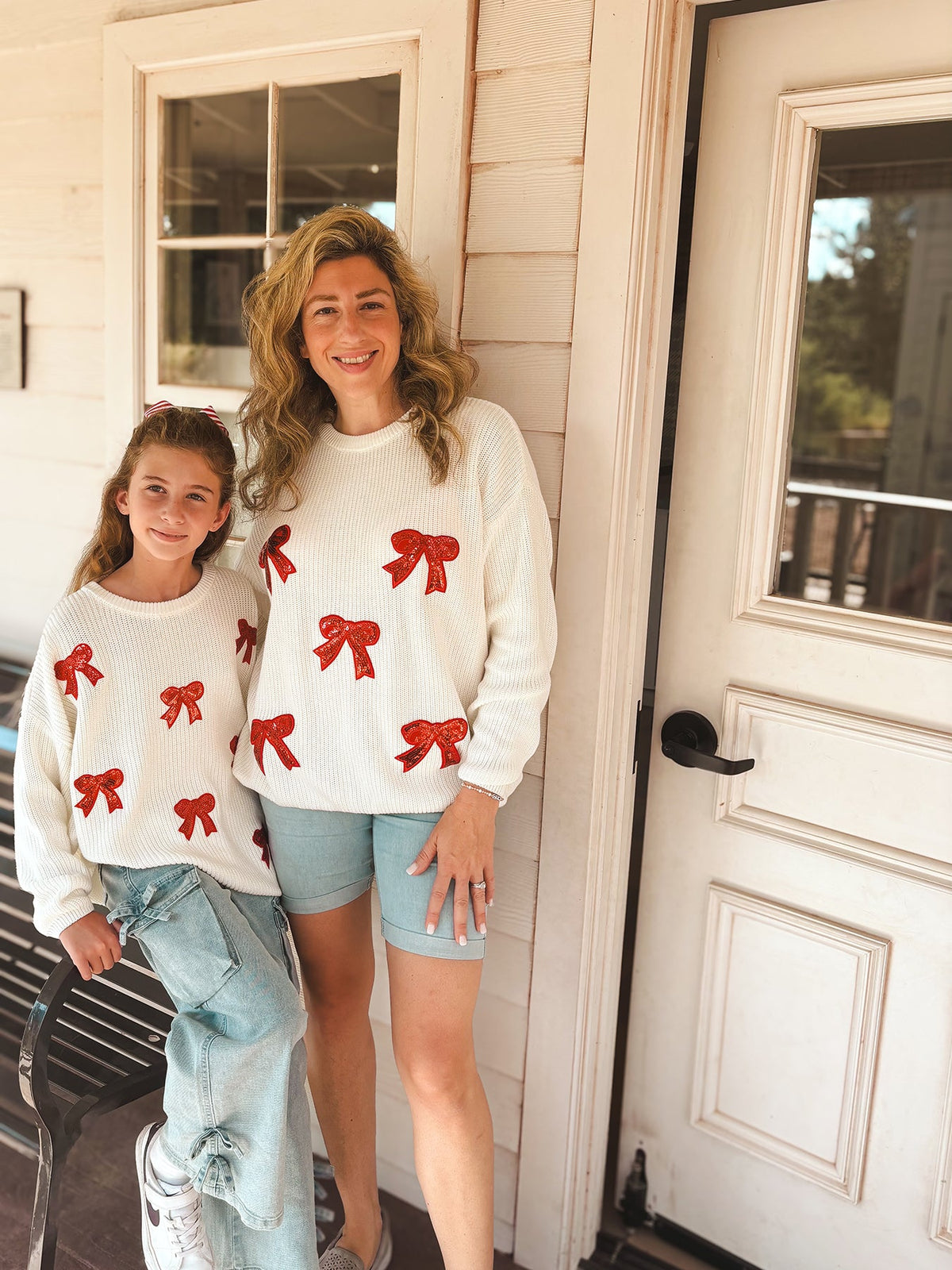 Mommy and Me Sweaters | Red Sequin Bows: Adult and child wearing cream bow sweaters