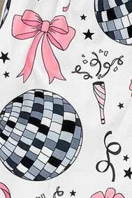 Children's outfit with patterned top and flared pants on a wooden surface