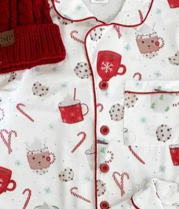 Children's pajama set with Christmas-themed design featuring red mugs, candy canes, and snowflakes on a white background.