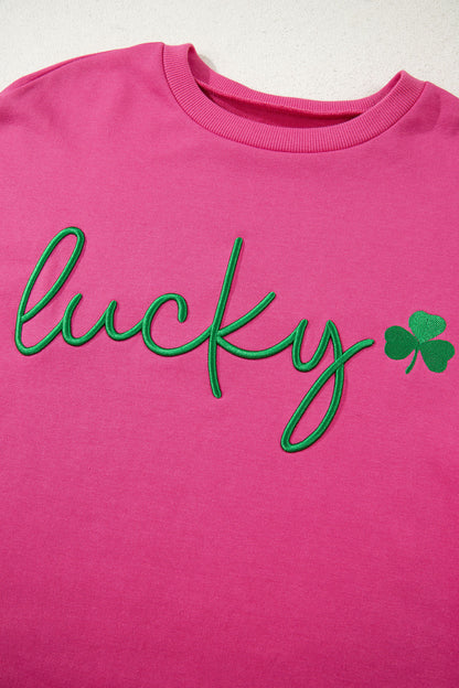Pink shirt with green 'lucky' text and shamrock on a white background