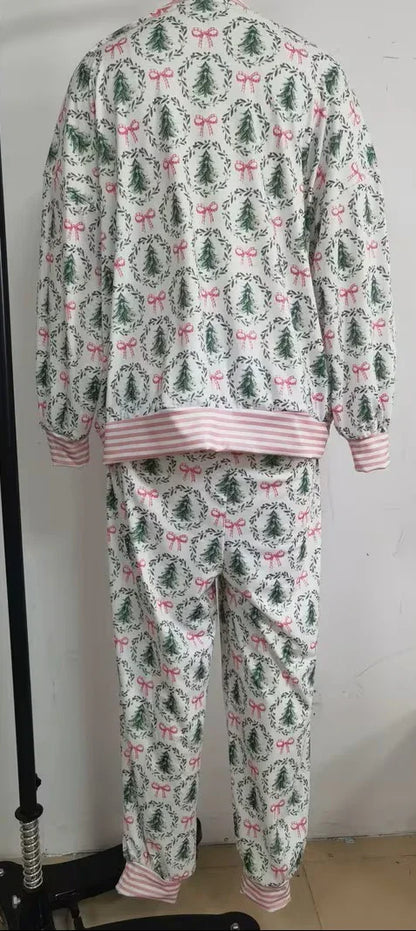 Christmas-themed pajama set with trees and bows on a plain background