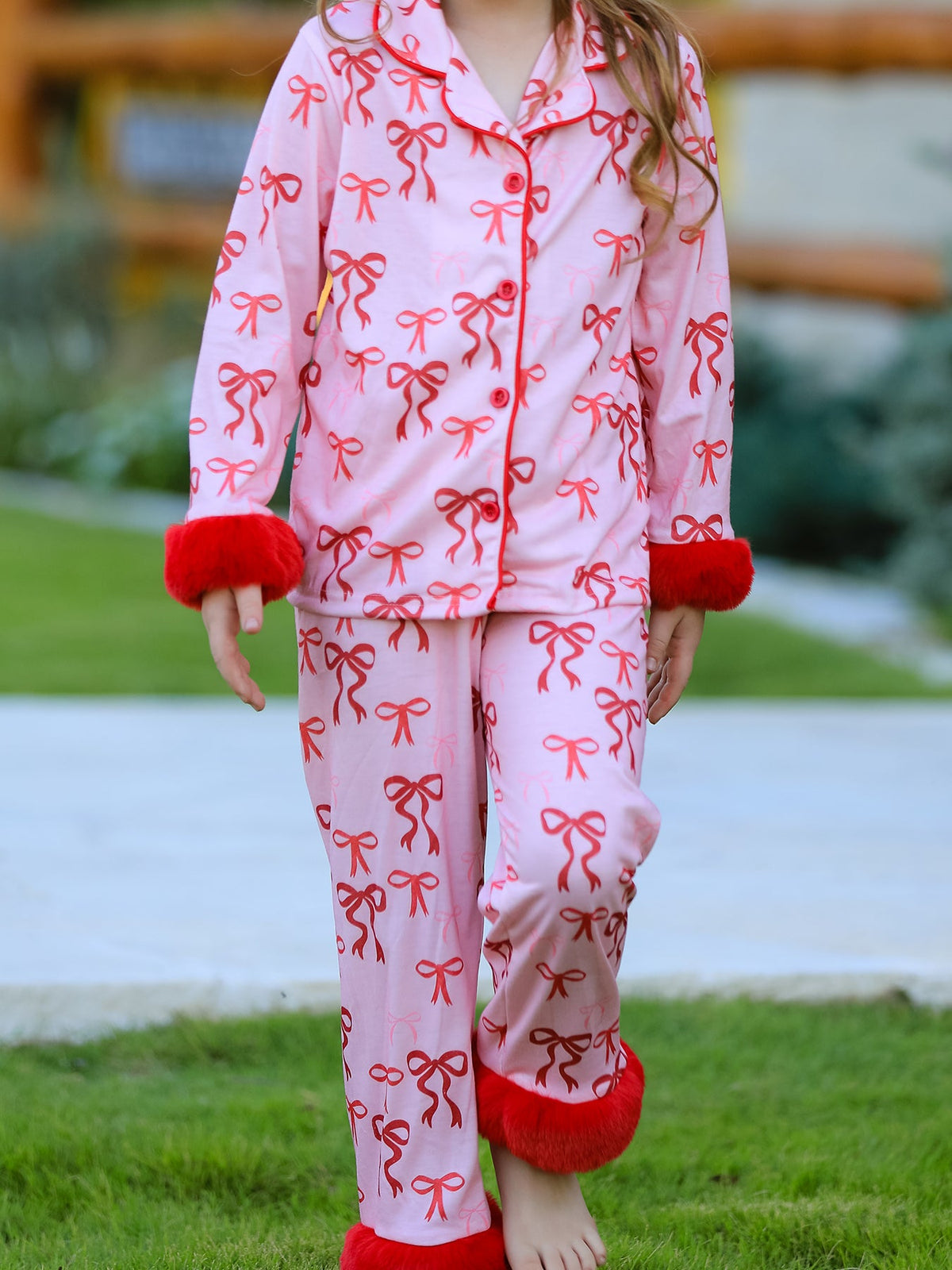 Girls Christmas Pajamas | Pink Bow Furry Trim: Model walking in bow-print pants