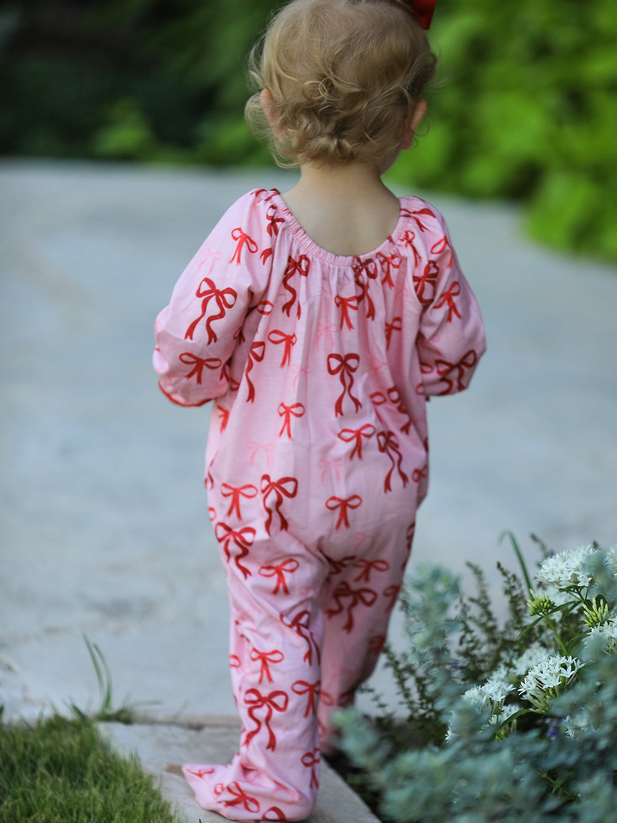 Baby Girl Romper | Pink Christmas Bow Print: Back view on baby